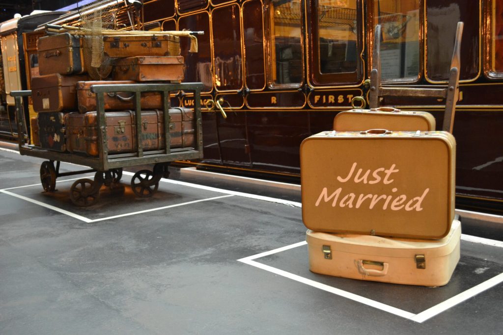 Valigia 'Just Married' accanto a un treno d'epoca, partenza per il viaggio di nozze