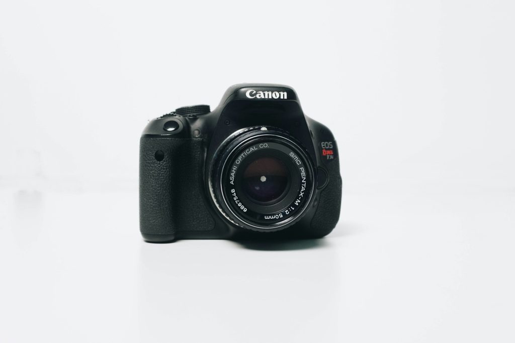 Fotocamera reflex con obiettivo fisso su fondo bianco
